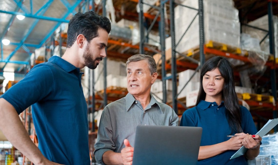 manager wearing grey shirt standing in warehouse